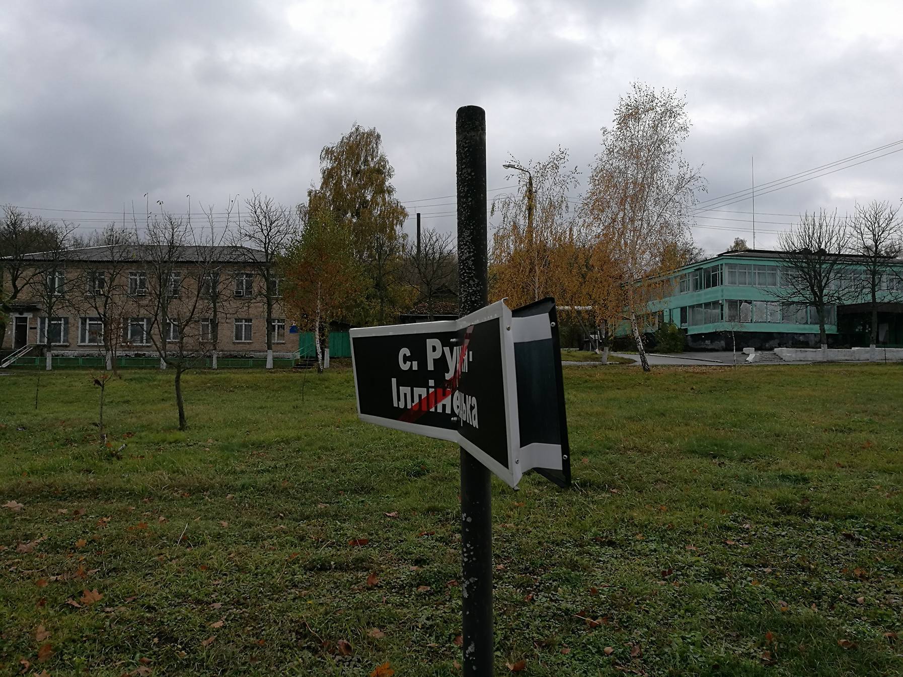 Uszkodzona tablica informacyjna symbolizująca wysiedloną 5 maja 1986 roku wieś Rudnia Ilińska